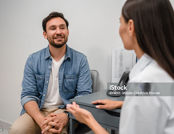 A patient smiling and talking with a doctor
